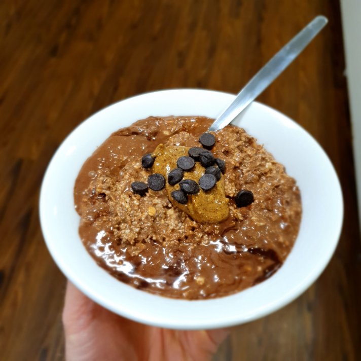 Chocolate Brownie Overnight Oats topped with peanut butter and chocolate chips
